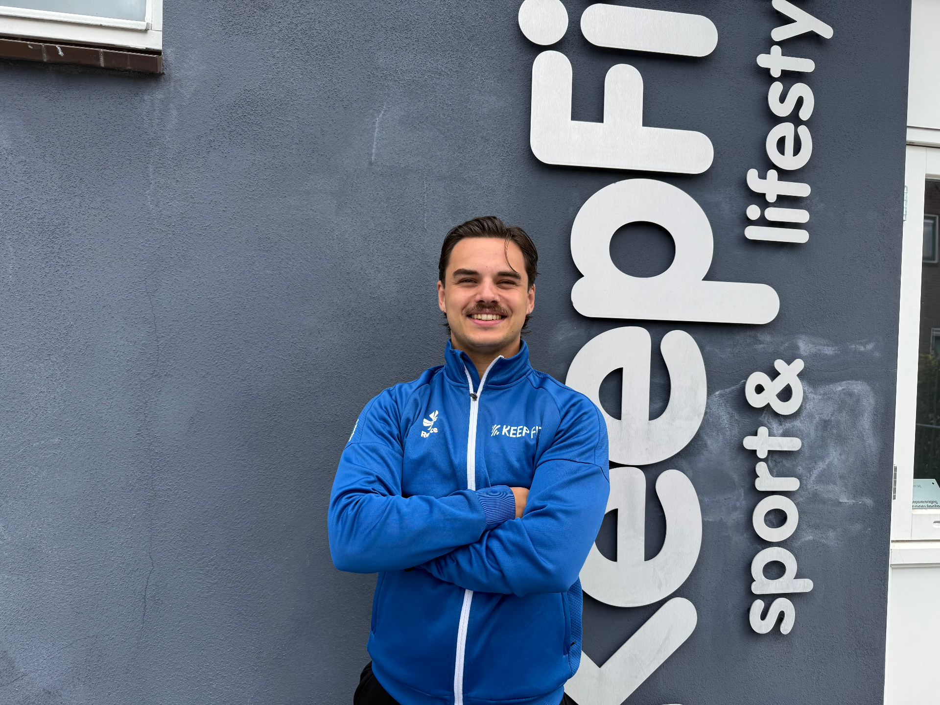 Jesse, fitness trainer bij Keep Fit Joure, in het blauwe Keep Fit trainingsjack