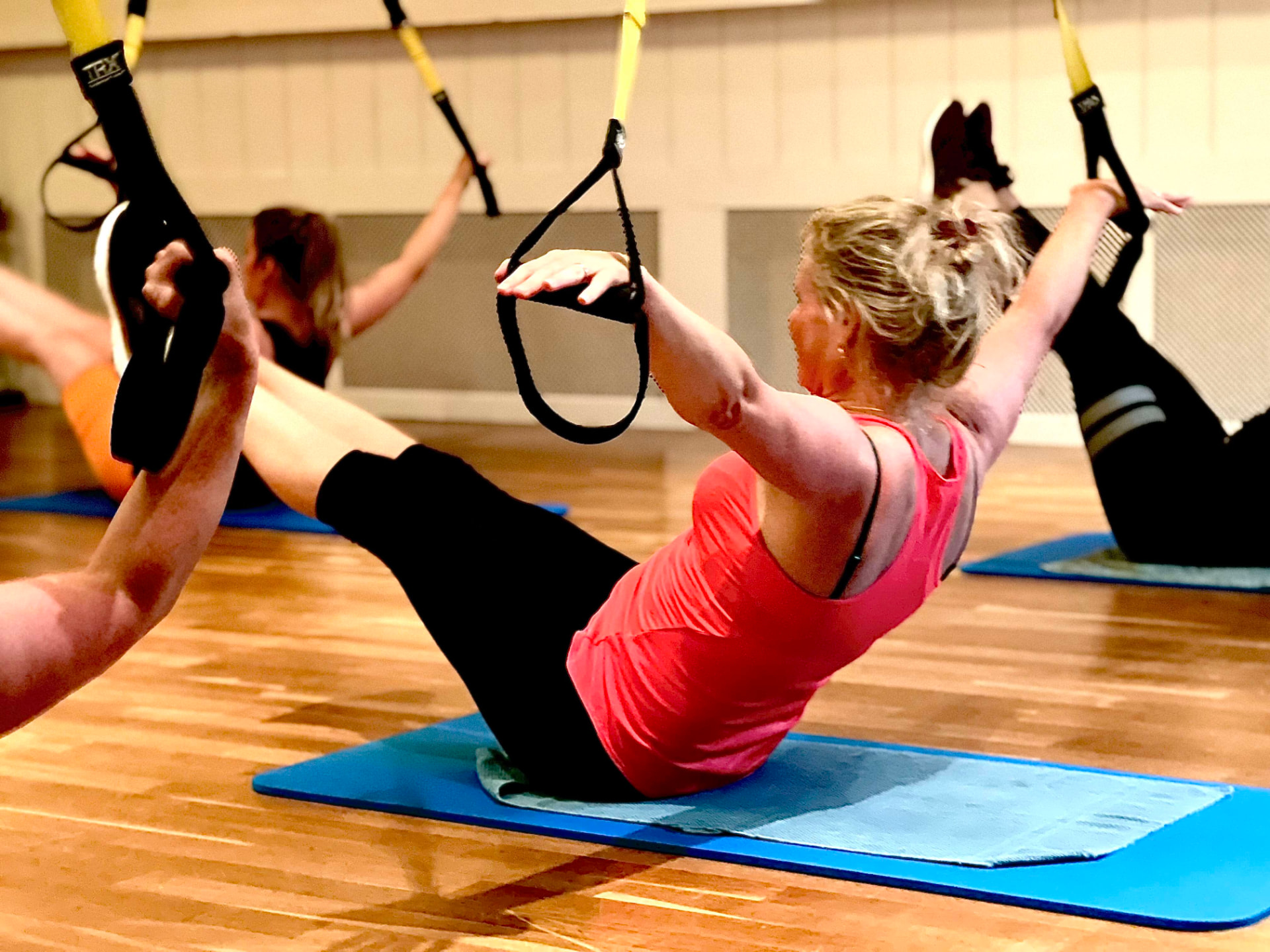 Deelnemer traint haar core met TRX-banden bij Keep Fit Joure