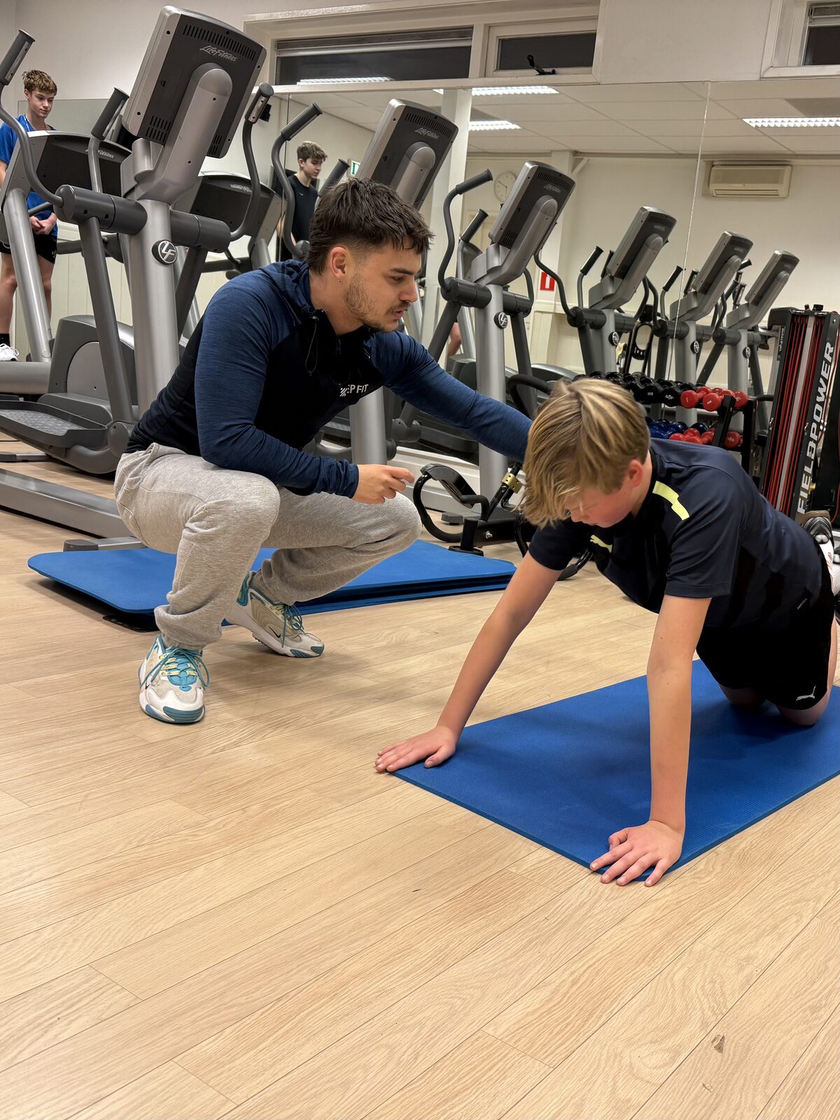 Trainer begeleidt een jongere tijdens jeugd fitness bij Keep Fit Joure