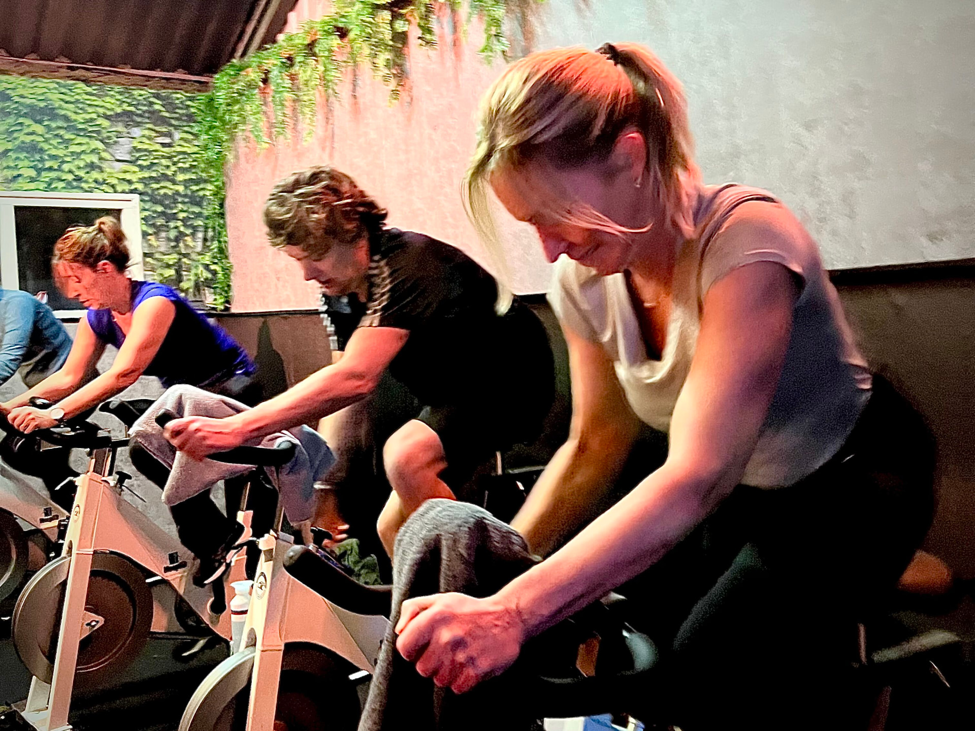 Sporters volgen een indoor cyclingles bij Keep Fit Joure